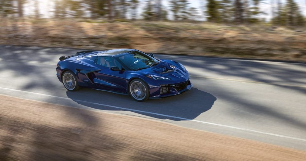 Passenger side view of Chevrolet Corvette ZR1 Convertible in Hysteria Purple driving down a mountain road